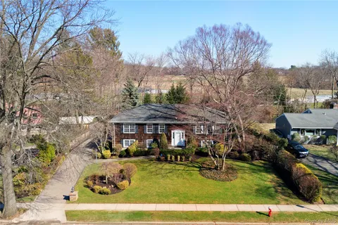 a view of a white house with a swimming pool and sitting area