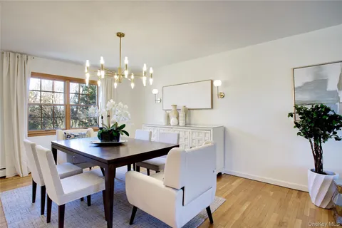 a large kitchen with a stove a sink dishwasher a dining table and chairs with wooden floor