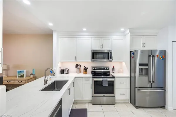 a kitchen with stainless steel appliances a refrigerator sink and microwave