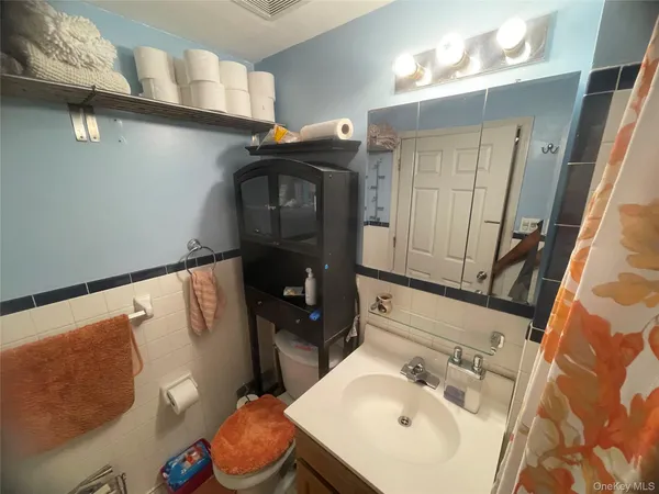 a bathroom with a sink vanity and toilet