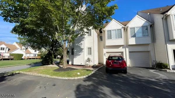 a view of a house with a big yard and large trees