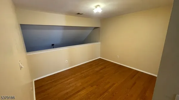 a view of a livingroom with wooden floor and staircase