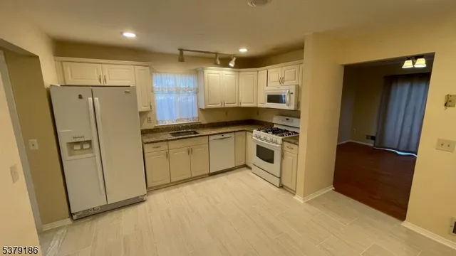 a kitchen with white cabinets and white stainless steel appliances
