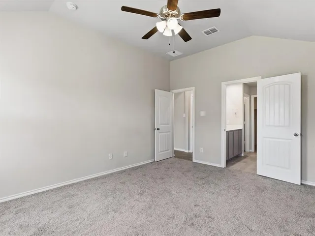 an empty room with a window and a ceiling fan