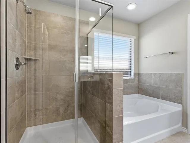 a bathroom with a tub sink and mirror