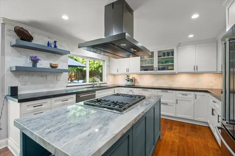 a kitchen with stainless steel appliances granite countertop wooden cabinets and a stove