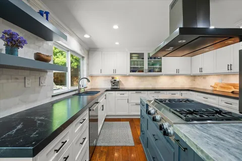 a kitchen with a stove a sink and a wooden cabinets