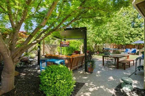 a view of a patio with table and chairs and potted plants with wooden floor and fence