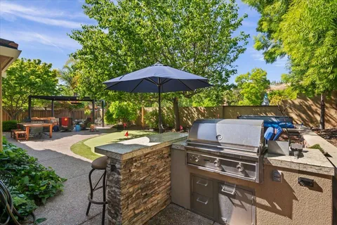 a view of a patio with table and chairs under an umbrella
