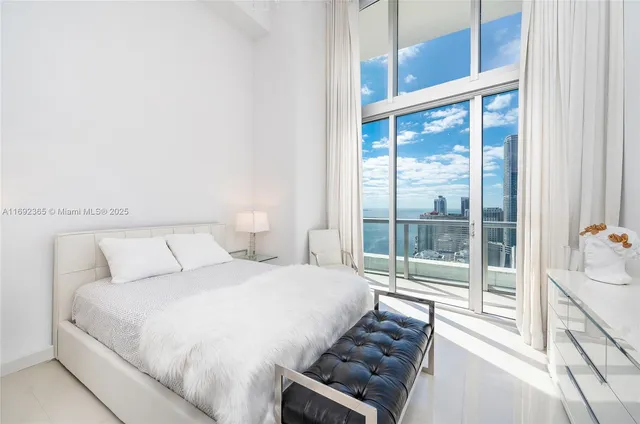 a bedroom with a bed and a large window