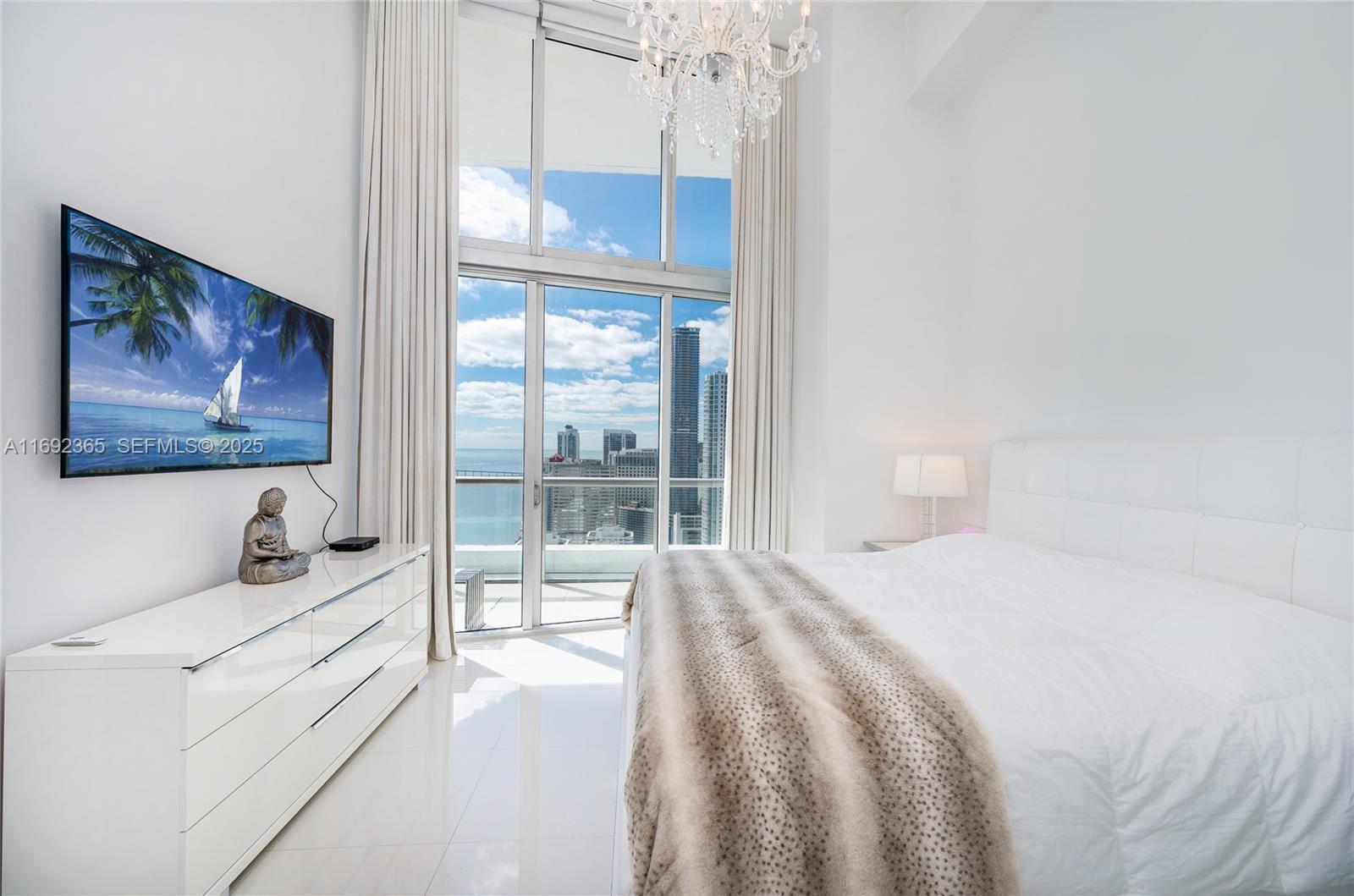 495 Brickell Avenue, Unit 4103 Miami, FL 33131 - Photo 7 of 27 a bedroom with a bed and a painting on the wall