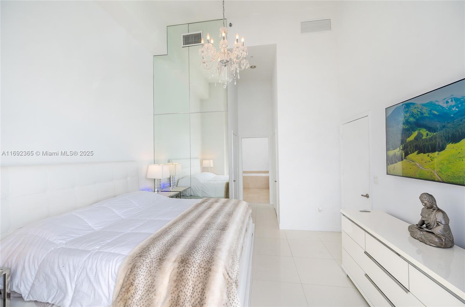 495 Brickell Avenue, Unit 4103 Miami, FL 33131 - Photo 8 of 27 a bedroom with a bed and a chandelier