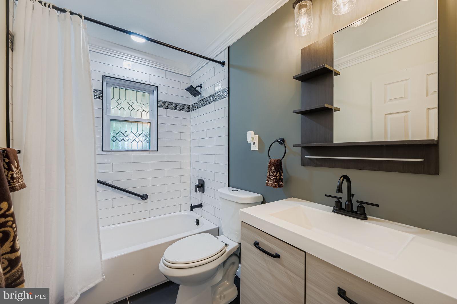 6205 Ridgeview Avenue Baltimore, MD 21206 - Photo 15 of 34 a bathroom with a sink a toilet and shower