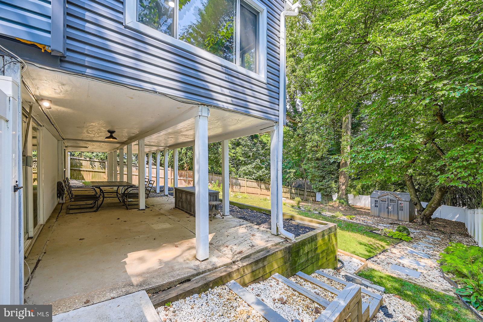 6205 Ridgeview Avenue Baltimore, MD 21206 - Photo 23 of 34 a view of a patio with table and chairs potted plants and large tree