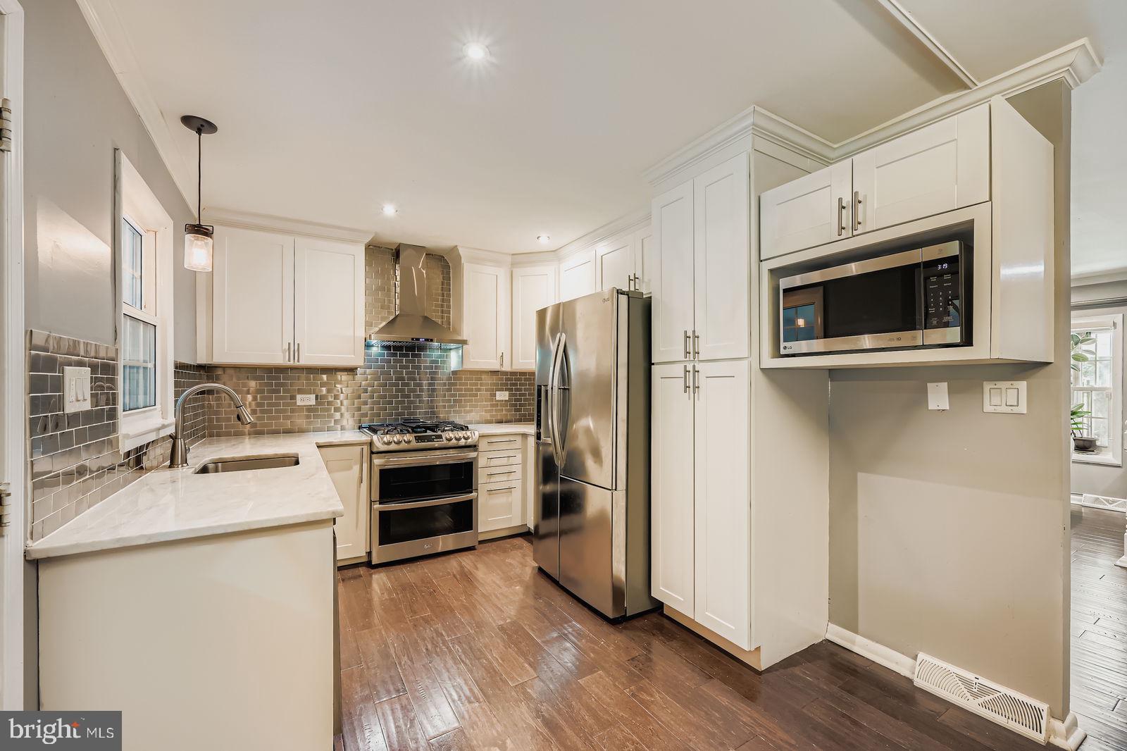 6205 Ridgeview Avenue Baltimore, MD 21206 - Photo 5 of 34 a kitchen with stainless steel appliances a stove a sink and a refrigerator