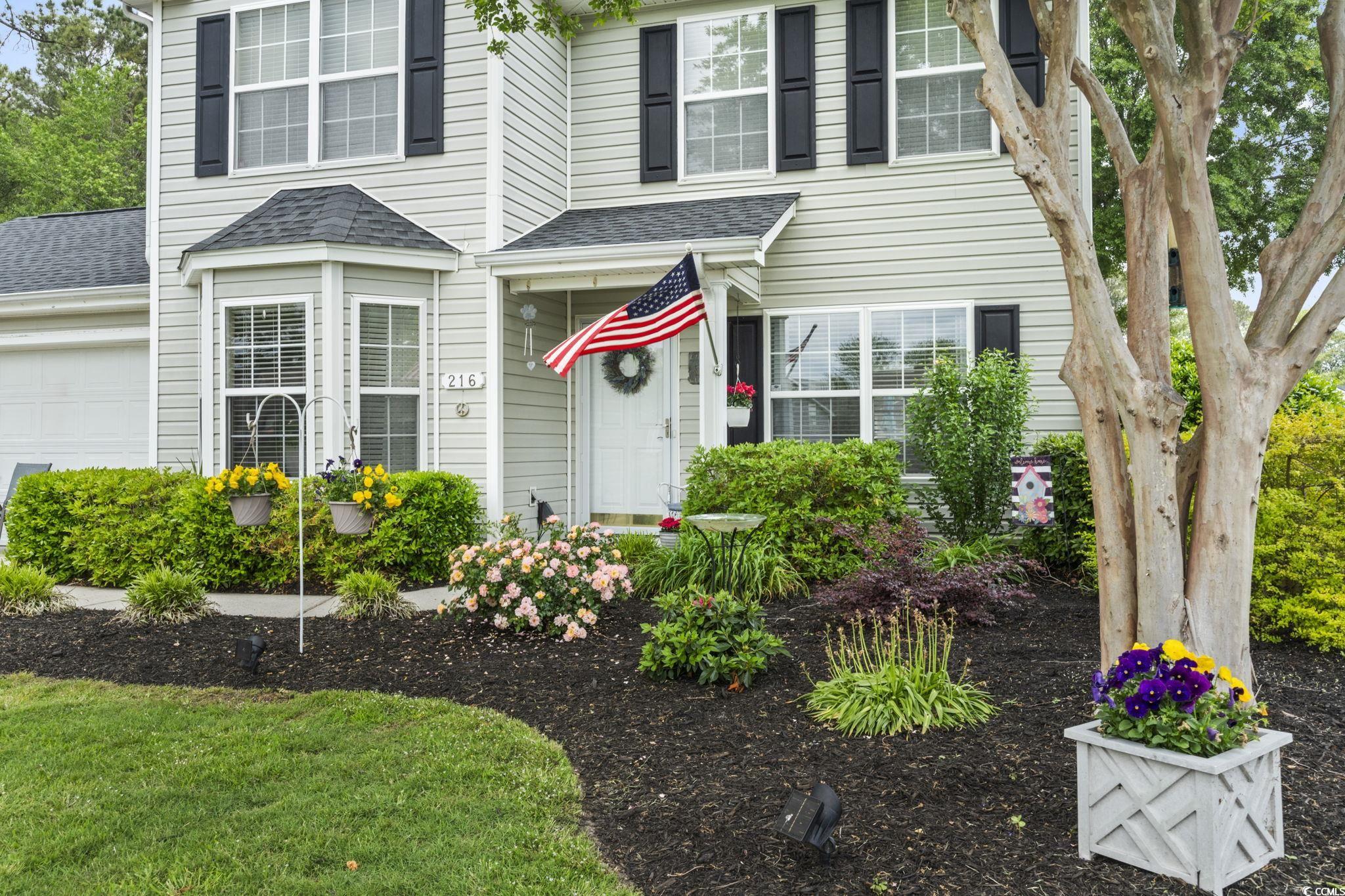 Traditional home featuring roof with shingles and