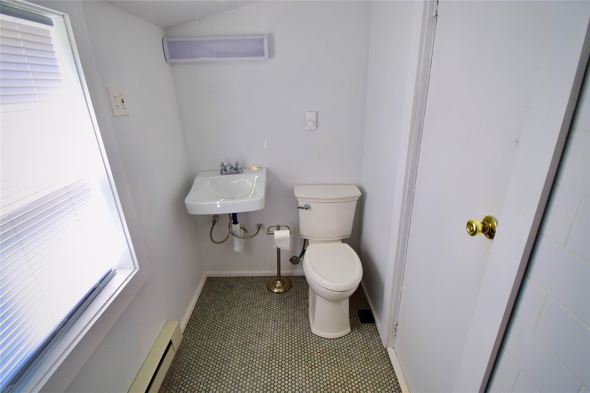 339 Mountain Lake Road Andes, NY 13731 - Photo 21 of 36 Bathroom featuring baseboard heating, sink, tile patterned flooring, and toilet