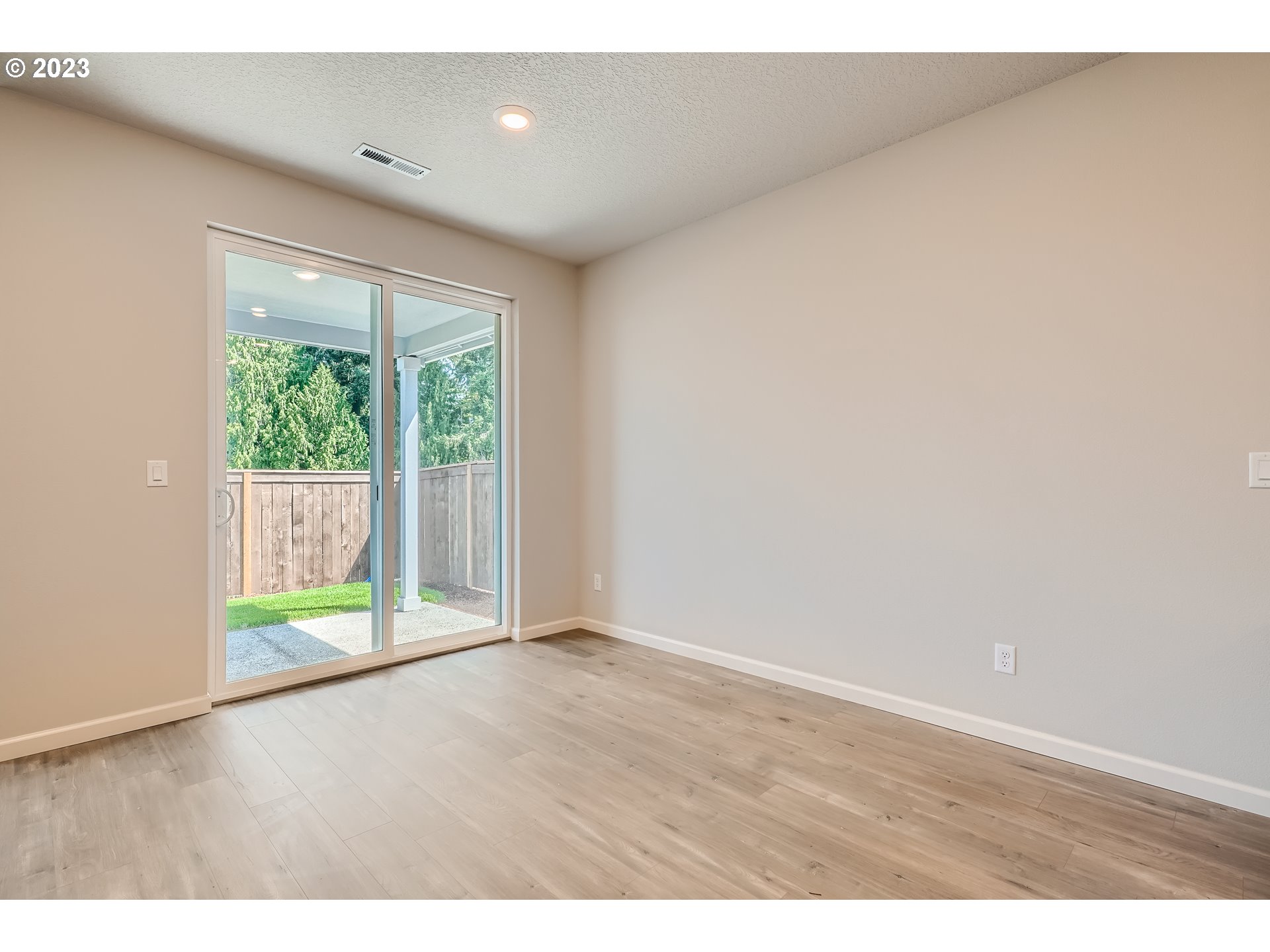 2816 South 7th Circle Ridgefield, WA 98642 - Photo 8 of 25 a view of an empty room with wooden floor and glass door