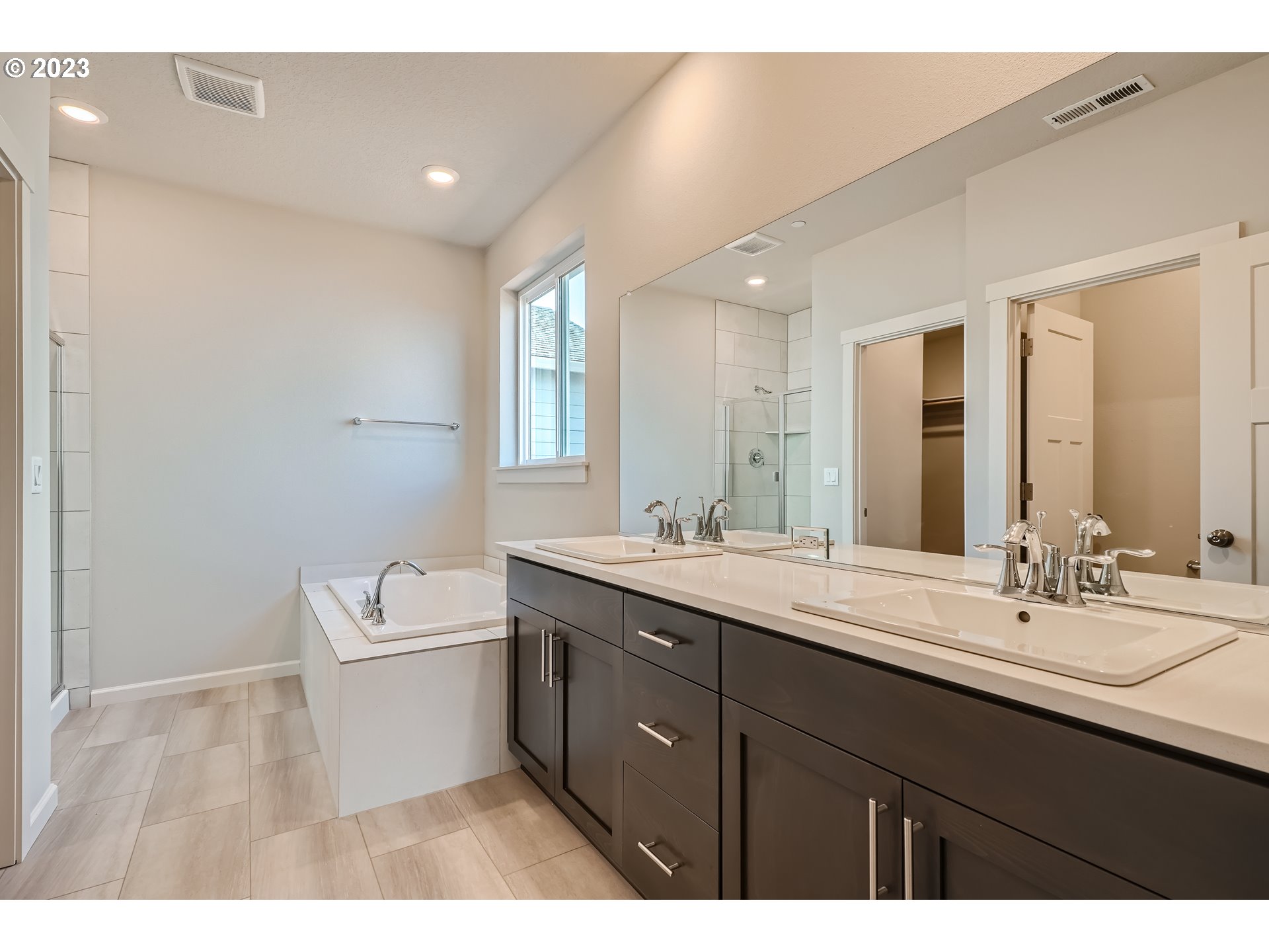 2816 South 7th Circle Ridgefield, WA 98642 - Photo 9 of 25 a bathroom with a double vanity sink a mirror and a bathtub