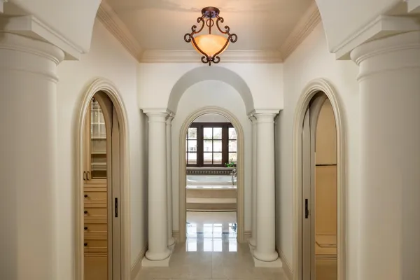 a bathroom with a tub a double vanity sink a large mirror and a bathtub next to a window