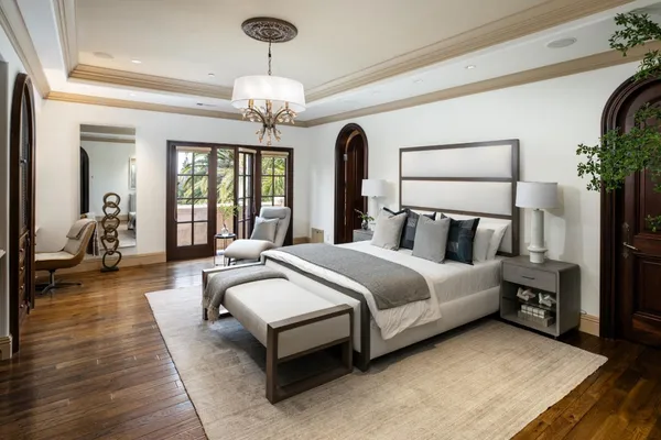 a bedroom with a large bed and a chandelier