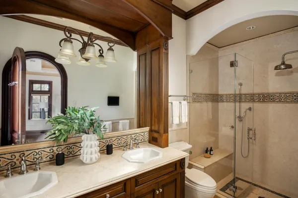 a bathroom with a granite countertop bathtub sink vanity mirror and toilet