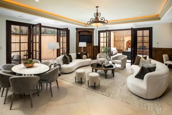 a living room with furniture a fireplace and a chandelier
