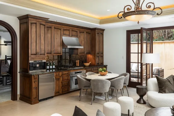 a view of a dining room with furniture one side kitchen view and wooden floor