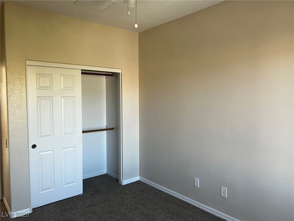 3417 West Birdwatcher Avenue North Las Vegas, NV 89084 - Photo 25 of 28 Unfurnished bedroom featuring dark colored carpet and a closet