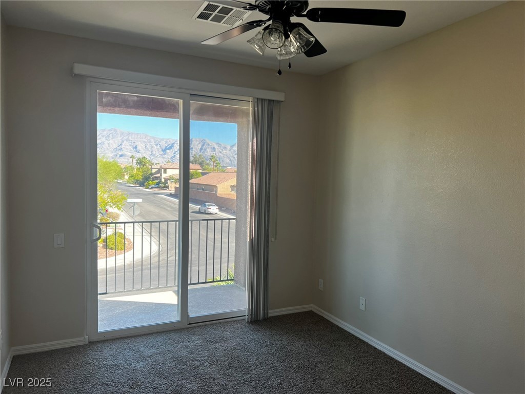 3417 West Birdwatcher Avenue North Las Vegas, NV 89084 - Photo 26 of 28 Unfurnished room with dark colored carpet, ceiling fan, and a mountain view
