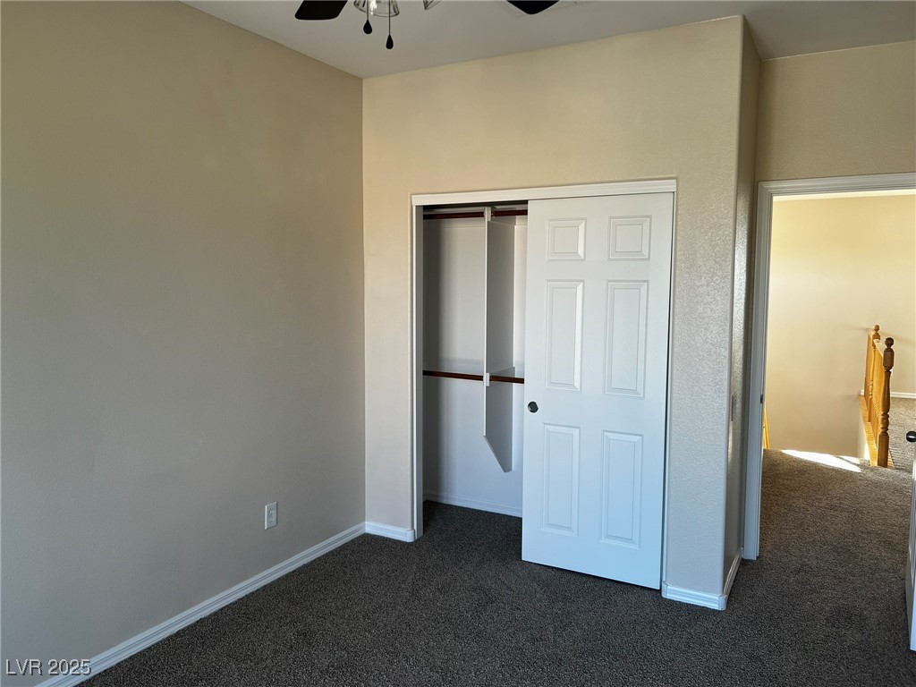 3417 West Birdwatcher Avenue North Las Vegas, NV 89084 - Photo 27 of 28 Unfurnished bedroom with dark carpet, a closet, and ceiling fan