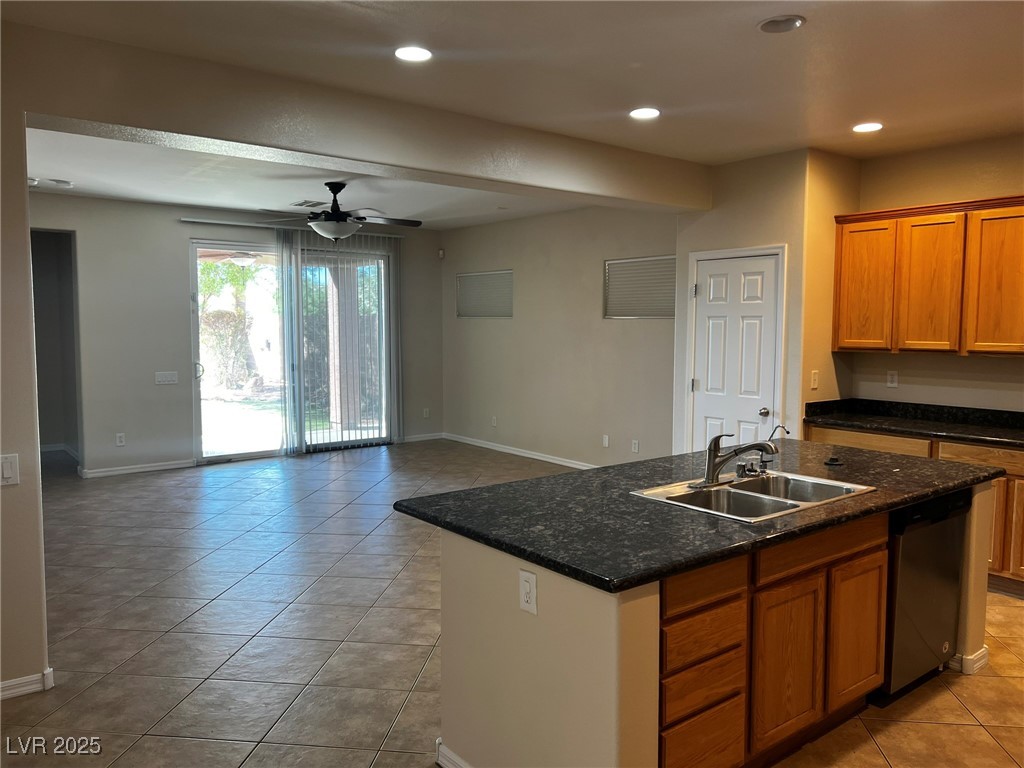 3417 West Birdwatcher Avenue North Las Vegas, NV 89084 - Photo 28 of 28 Kitchen featuring open floor plan, brown cabinets, ceiling fan, dishwasher, and light tile patterned floors