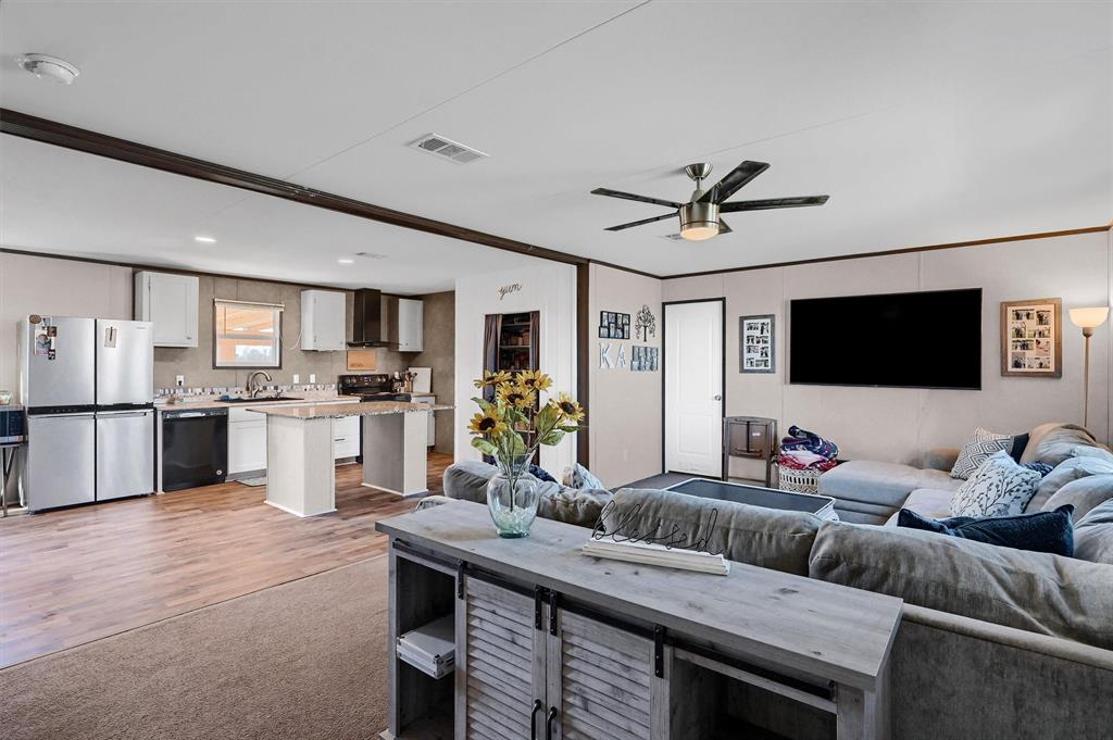a living room with furniture kitchen view and a flat screen tv