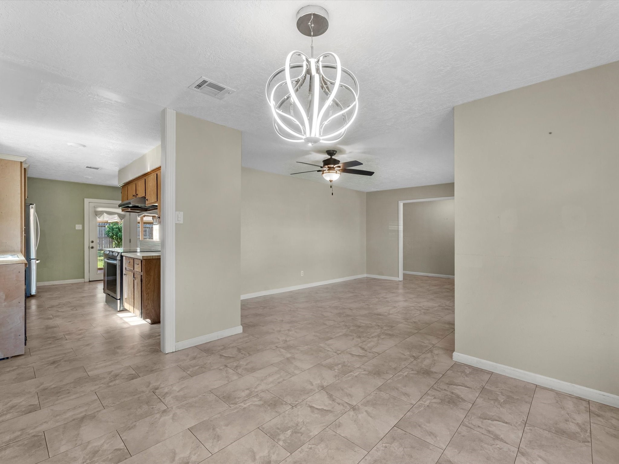 4318 Ponca Street Pasadena, TX 77504 - Photo 11 of 22 an empty room with kitchen view and a chandelier