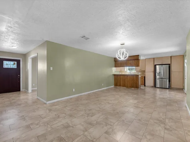 a view of an empty room with window and cabinet