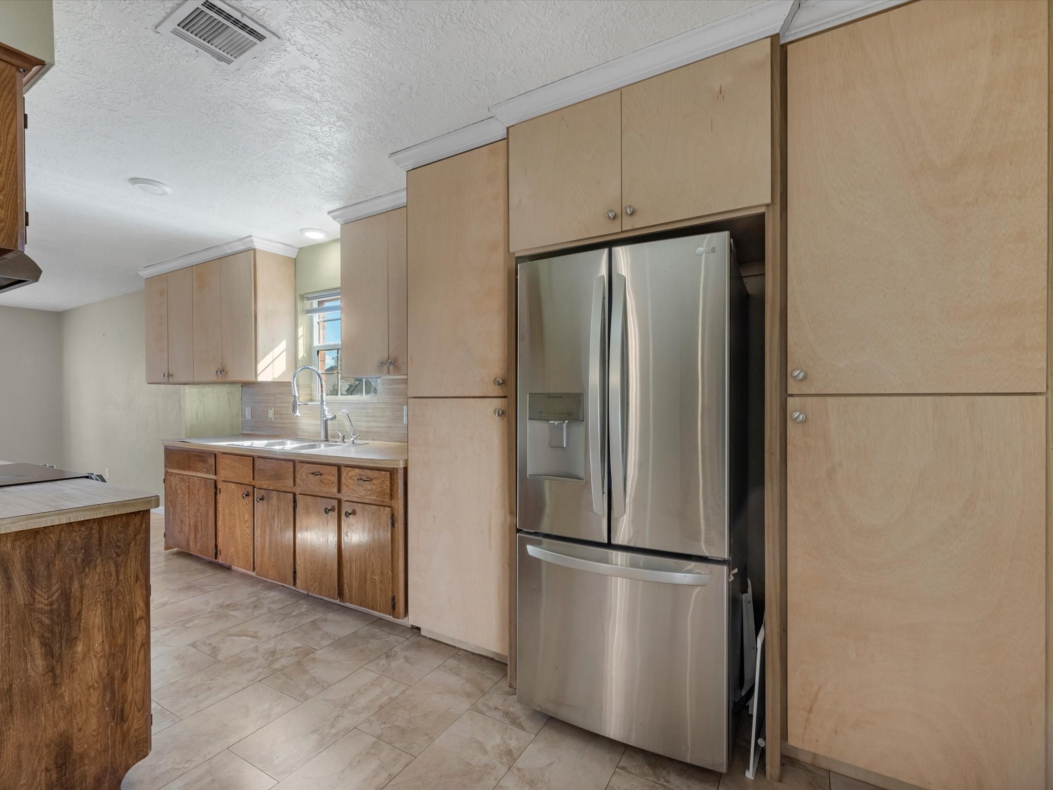 4318 Ponca Street Pasadena, TX 77504 - Photo 6 of 22 a kitchen with stainless steel appliances a refrigerator and a sink