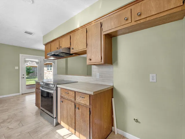 a kitchen with granite countertop a stove and a sink