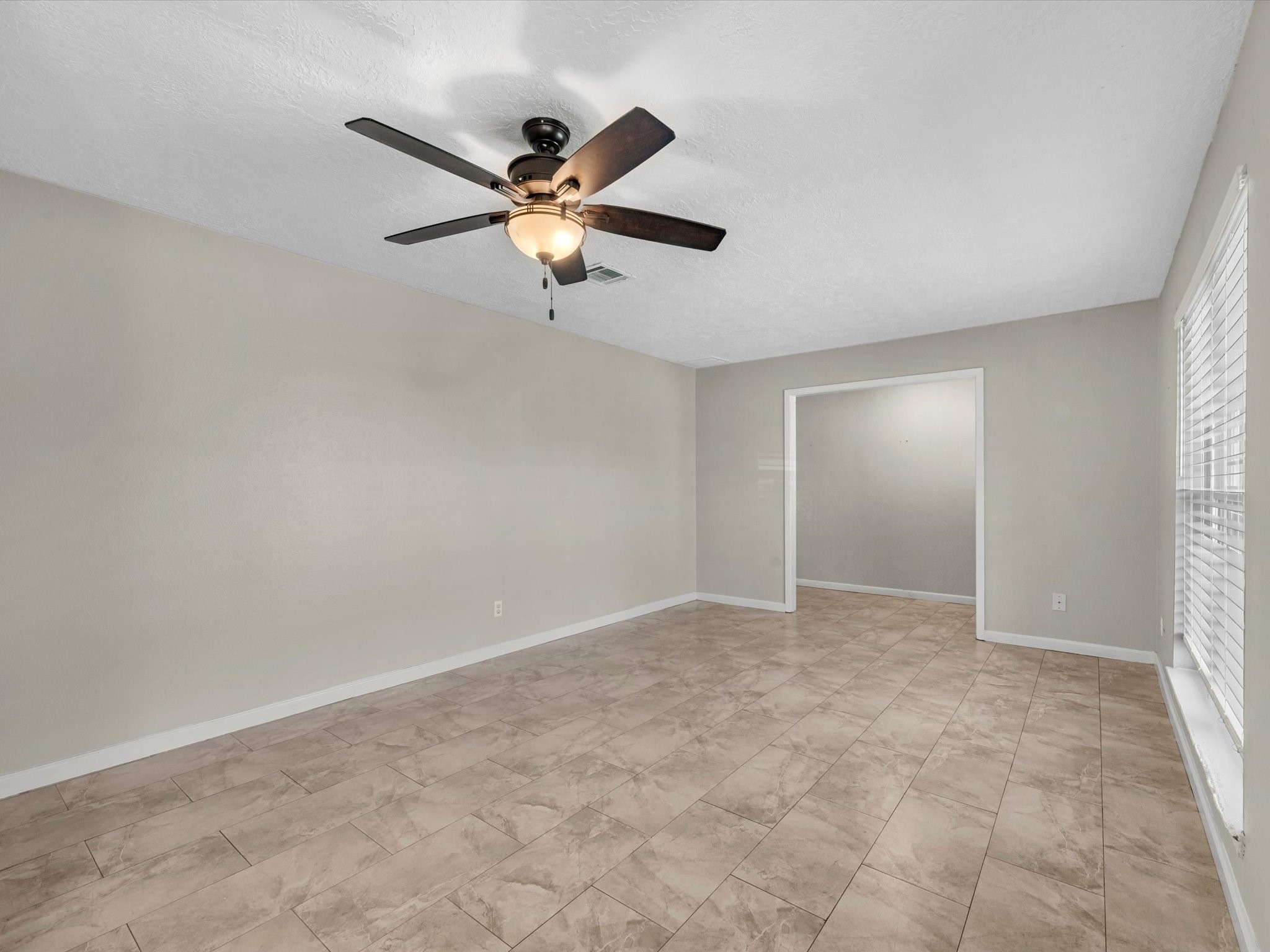 4318 Ponca Street Pasadena, TX 77504 - Photo 9 of 22 an empty room with windows and fan