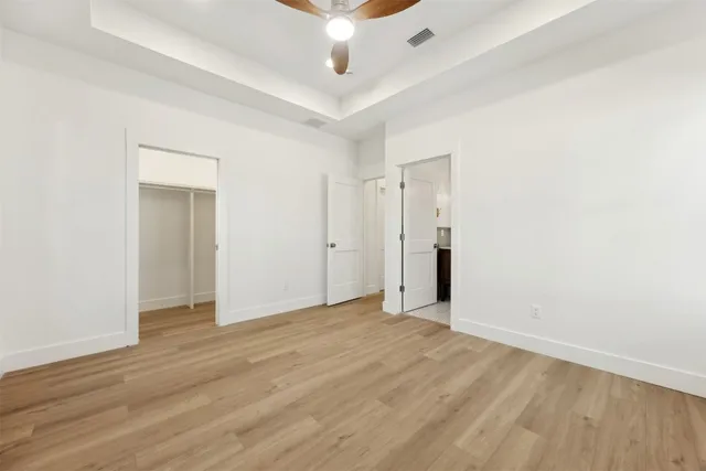 an empty room with wooden floor and bathroom