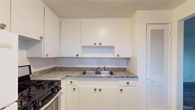 a kitchen with granite countertop a stove and a sink