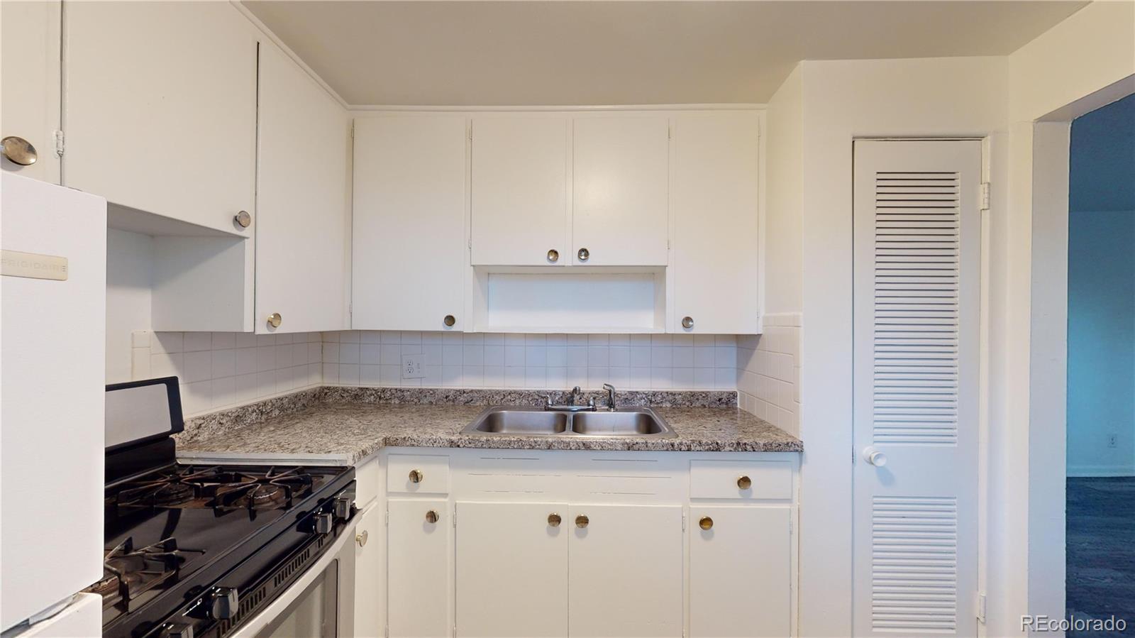 1251 Upham Street, Unit 8 Lakewood, CO 80214 - Photo 12 of 38 a kitchen with granite countertop a stove and a sink