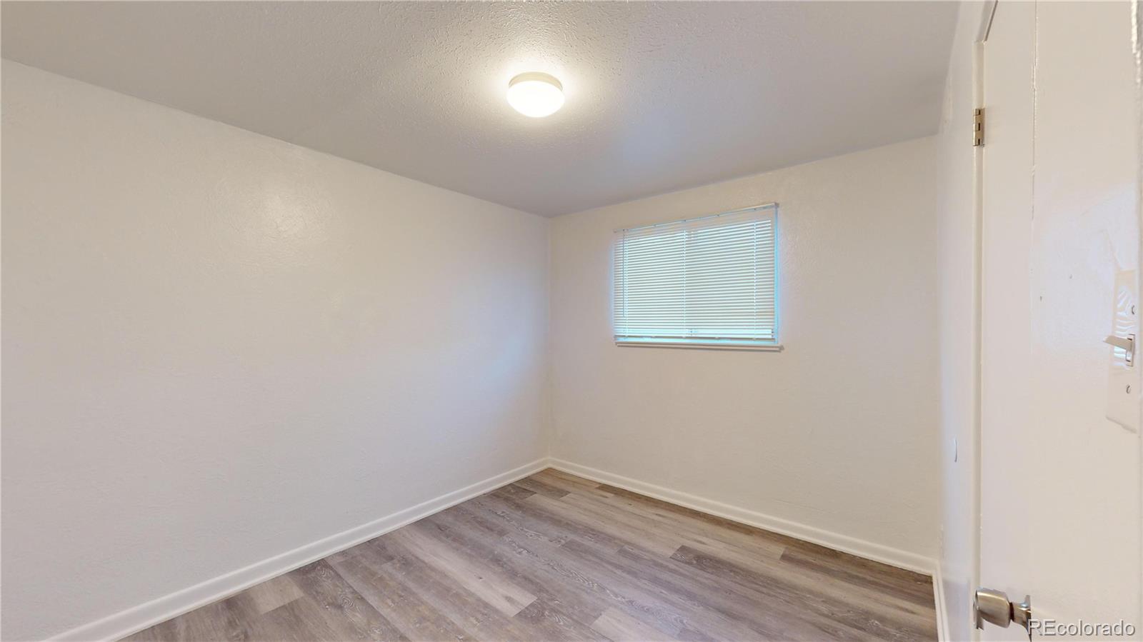 1251 Upham Street, Unit 8 Lakewood, CO 80214 - Photo 14 of 38 an empty room with wooden floor and windows
