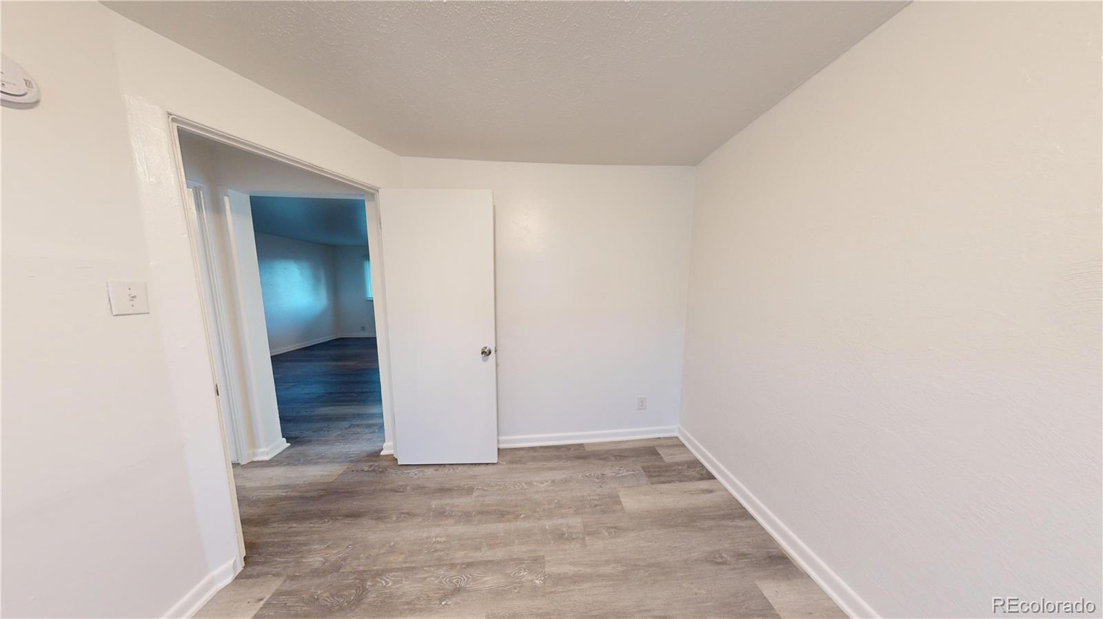 1251 Upham Street, Unit 8 Lakewood, CO 80214 - Photo 15 of 38 an empty room with an entryway door