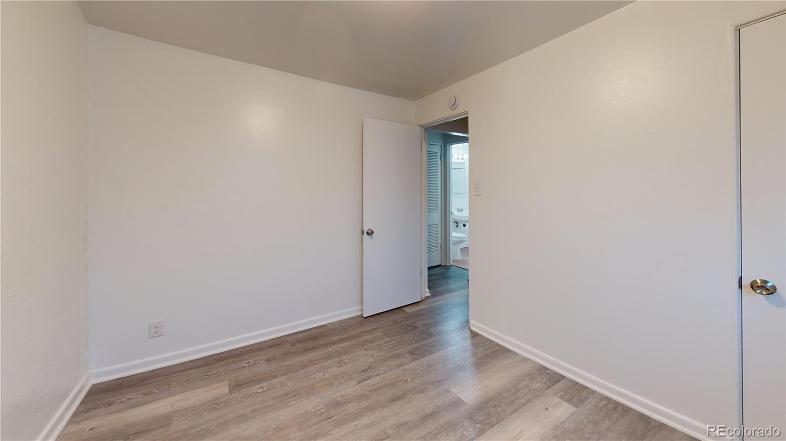 1251 Upham Street, Unit 8 Lakewood, CO 80214 - Photo 20 of 38 a view of an empty room with wooden floor
