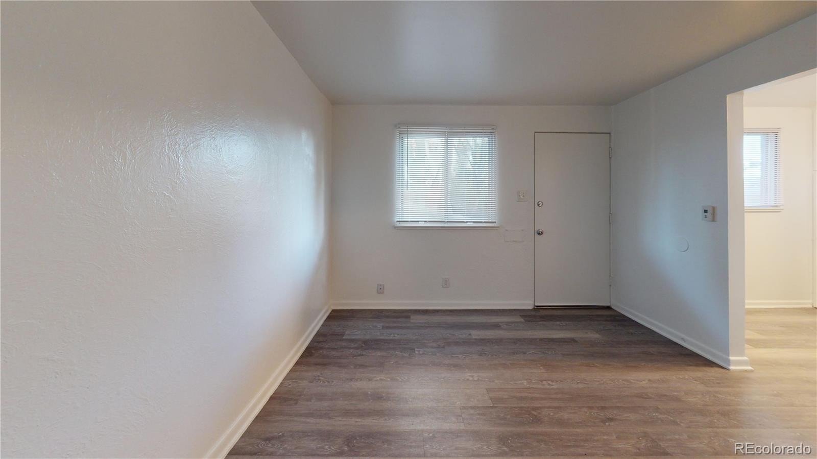 1251 Upham Street, Unit 8 Lakewood, CO 80214 - Photo 21 of 38 an empty room with wooden floor and windows