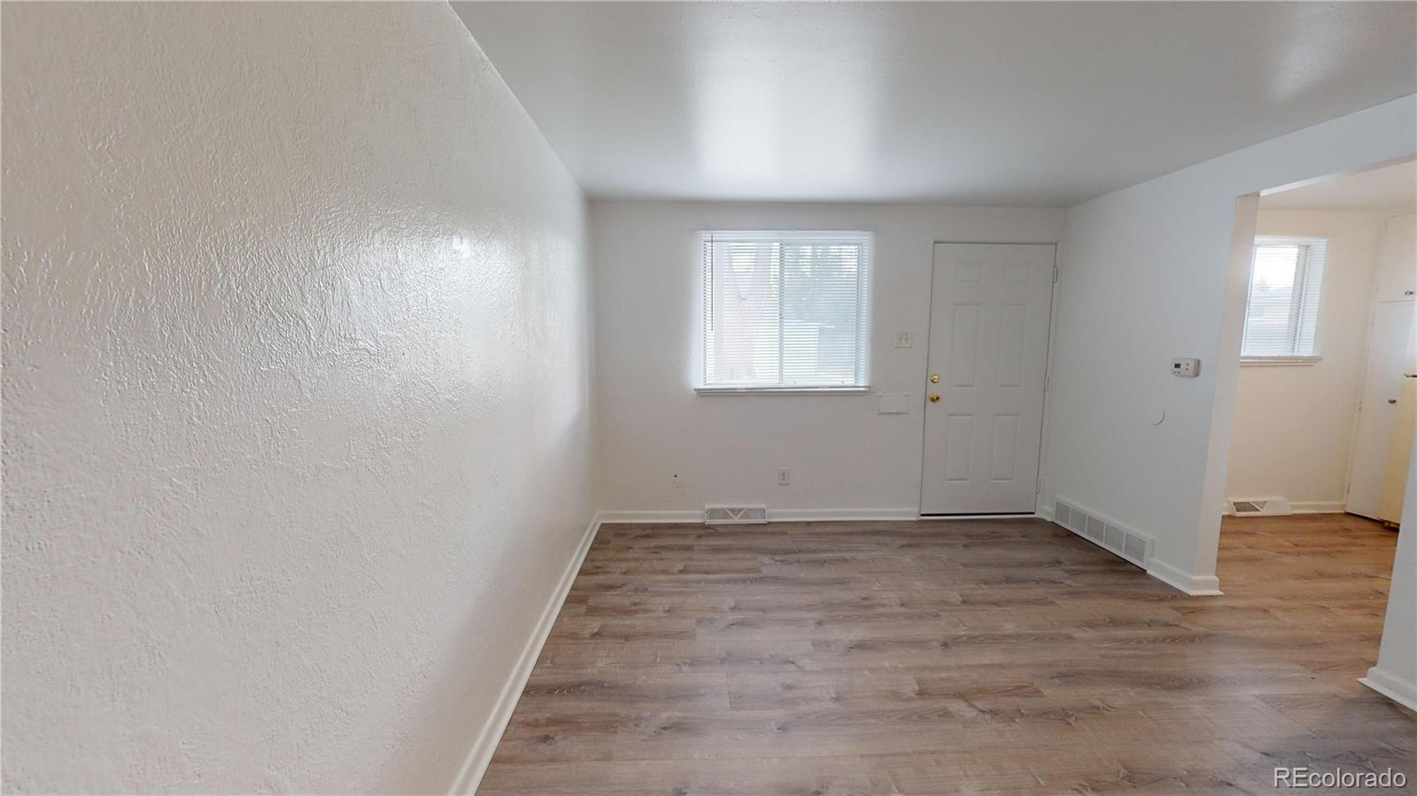 1251 Upham Street, Unit 8 Lakewood, CO 80214 - Photo 25 of 38 an empty room with wooden floor and windows
