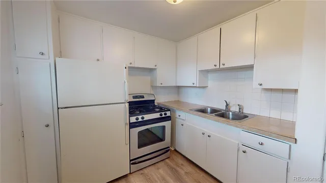 a kitchen with cabinets stainless steel appliances and sink