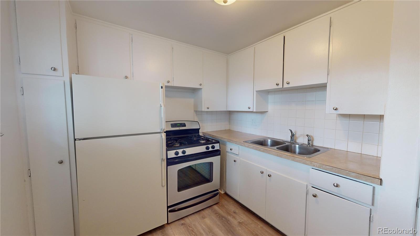 1251 Upham Street, Unit 8 Lakewood, CO 80214 - Photo 27 of 38 a kitchen with cabinets stainless steel appliances and sink