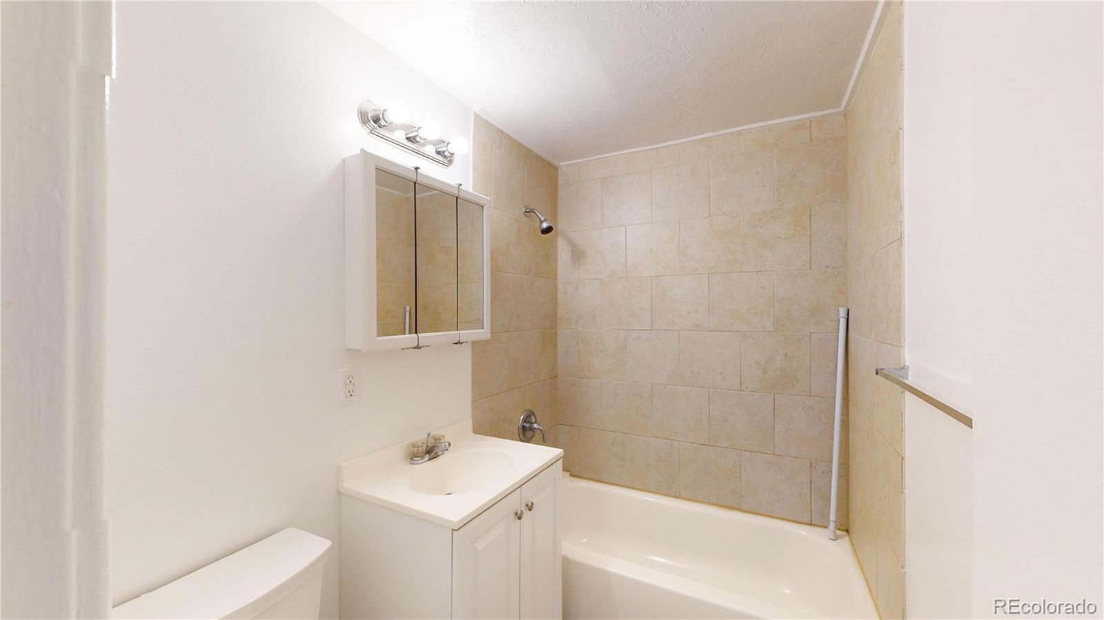 1251 Upham Street, Unit 8 Lakewood, CO 80214 - Photo 28 of 38 a bathroom with a sink a shower and a mirror