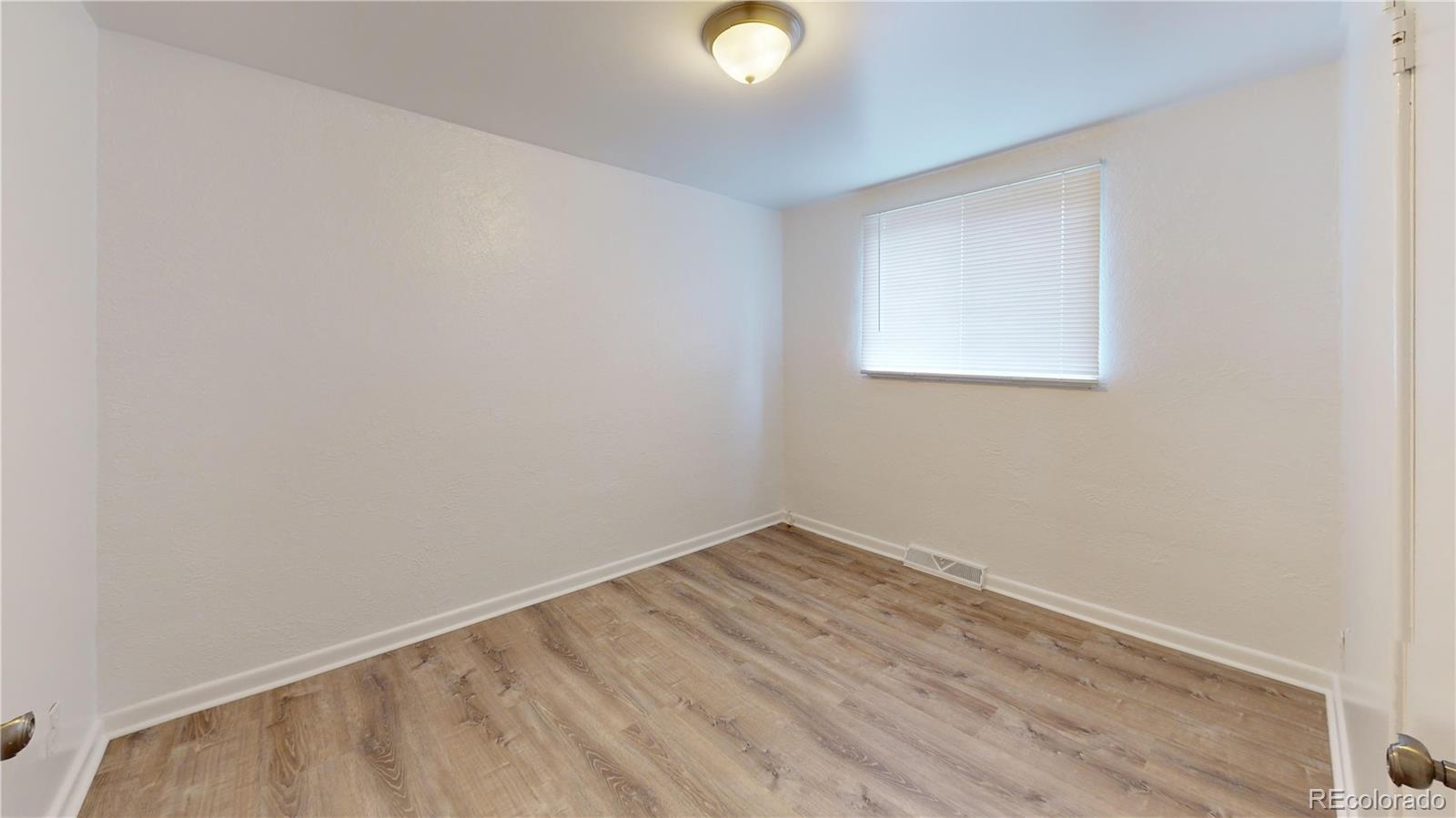 1251 Upham Street, Unit 8 Lakewood, CO 80214 - Photo 34 of 38 a view of an empty room with wooden floor and a window